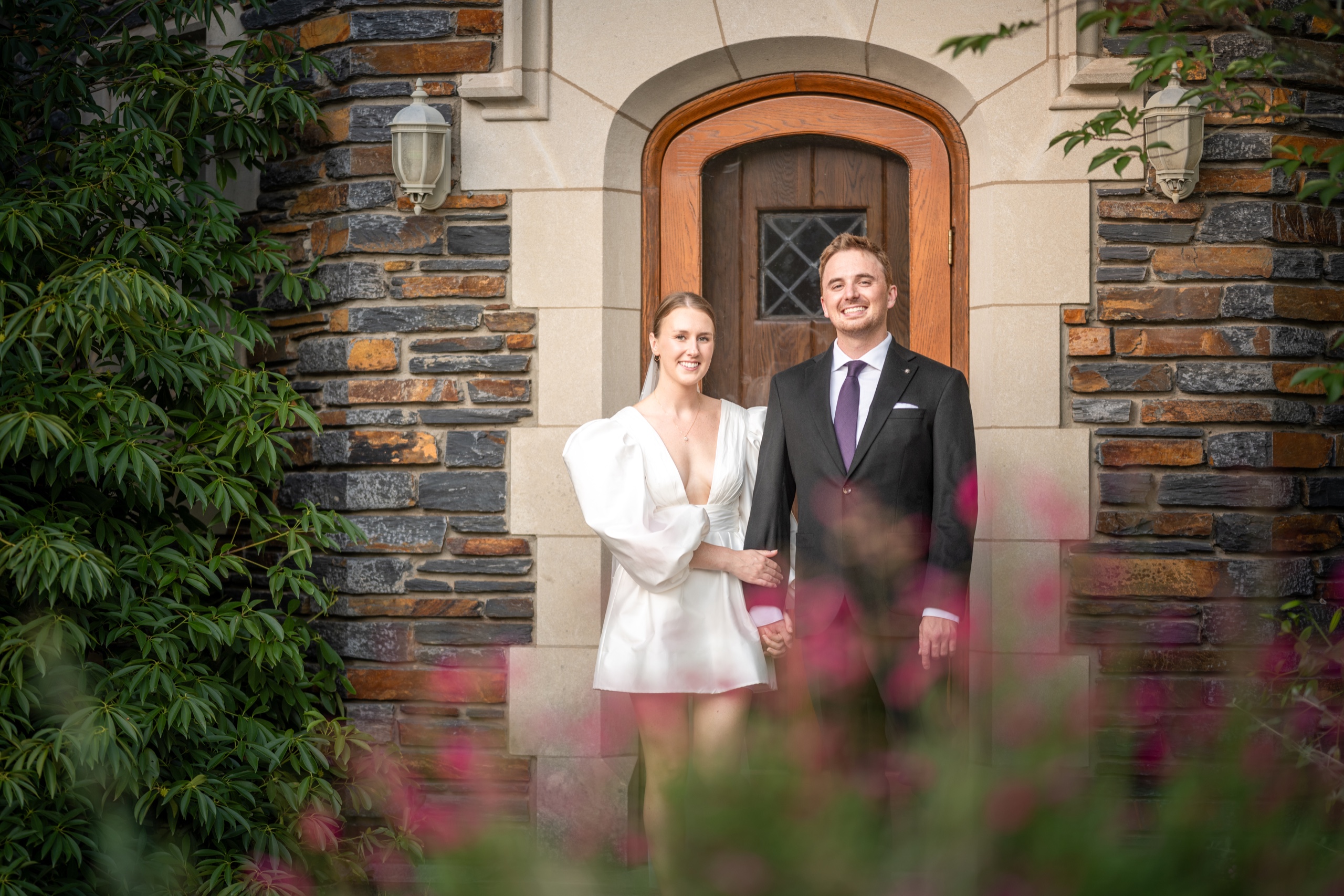 Engagement portrait framed by greenery and architecture